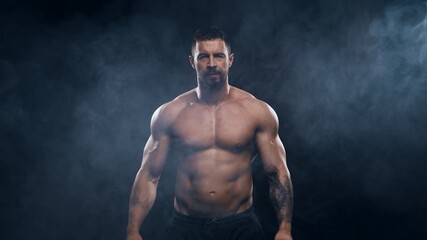 Fit and sporty bodybuilder over black background. Sportsman in studio. Sport and fitness concepts.