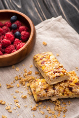 delicious muesli bars on napkin with blurred berries