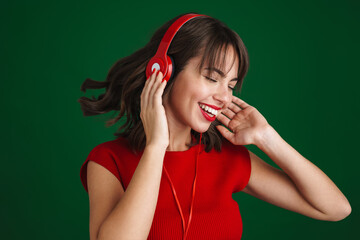 Beautiful happy girl listening music with headphones and dancing