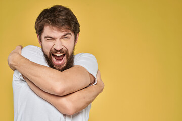 Bearded man in white t-shirt emotions close-up fun yellow background