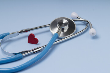 Red heart with stethoscope on blue background.