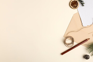 Creative Christmas layout made with envelope, blank paper note card, fir and pencil on vanilla background. Minimal New Year seasonal greeting card concept. Flat lay.