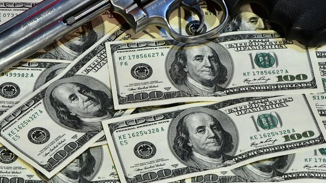 Revolver Smith e Wesson 357 magnum on a dollar background of 100 dollars banknotes treasure of a bank robbery. concept of money and guns