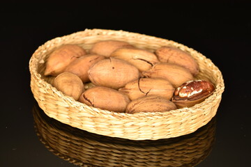 Several ripe unpeeled pecans, close-up, isolated on black.