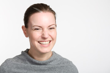 headshot of a laughing young woman in a grey sweate