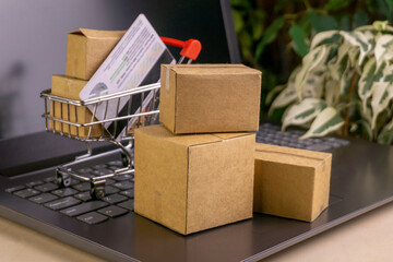 online shopping concept. little deliver boxes, smartphone, shopping bags, shopping bascket stand on laptop. copy space