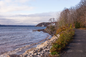Fototapeta na wymiar Late Fall back view of man strolling on the Jacques-Cartier Walk along the St. Lawrence River in the Cap-Rouge area, Quebec City, Quebec, Canada