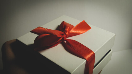 Present. White box with a red ribbon.