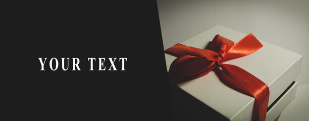 Present. White box with a red ribbon. The photo has a place for text on a white background. Design for banners, business cards, flyers and more.