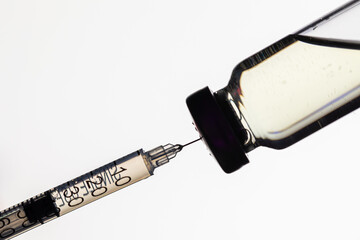 Bottle with coronavirus covid-19 vaccine and syringe on white background.