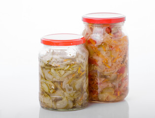 Fototapeta na wymiar Glass jars of pickled homemade organic cucumber carrrot with garlic and red cabbage vegetables isolated on white background 