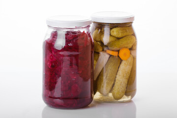 Glass jars of pickled homemade organic red cabbage with vegetables  isolated on white background 