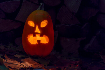 A glowing pumpkin on autumn distyas and against the background on the night of Helovin