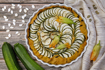 Homemade delicious pie with zucchini, cheese and basil on a white dish