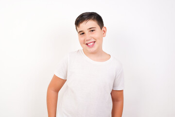 Portrait of successful Caucasian young boy standing against white background , smiling broadly with self-assured expression. Confidence and business concept.