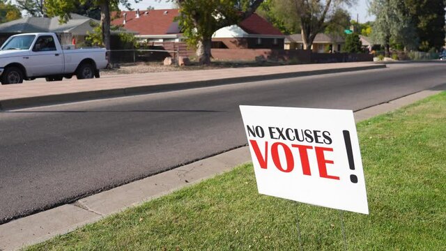 Campaign Voter Rally Sign Next to Road with Cars Driving By, No Excuses Vote!