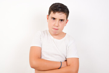 Caucasian young boy standing against white background, making money gesture.