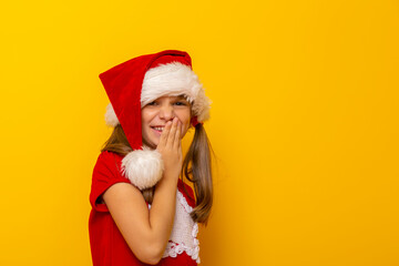 Little girl wearing Santa hat giggling