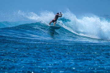 Surfer on perfect blue aquamarine wave, empty line up, perfect for surfing, clean water, Indian Ocean