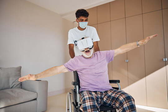 Male pensioner playing a 3D game in VR goggles