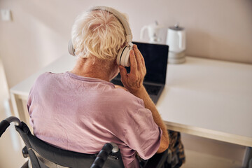 Modern Caucasian male pensioner listening to music