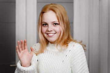 beautiful red-haired girl shyly waves her hand. expression of emotion