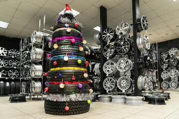 Christmas tree made of car tires and wheels, installed in a car shop selling spare parts, tires and alloy wheels. © Vladimir Razgulyaev
