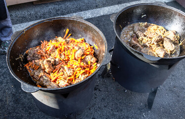 Cooking appetizing pieces of meat in a large cauldron