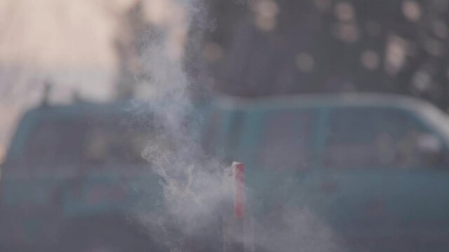 Smoke burning down a tube and a firework goes off in slow motion.