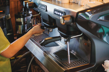  Barista prepares to make coffee with a coffee machine.