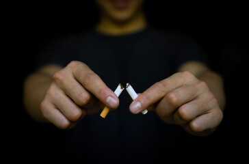 Hands of a young man who broke cigarettes as a reminder of quitting smoking, World No Tobacco Day concept.