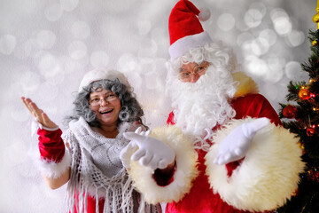 elderly santa claus with his wife congratulates children and adults, shows with hands, concept of christmas, childhood, festive mood, congratulations, good wishes