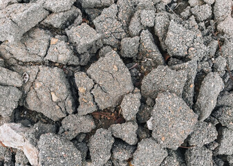 Texture, the background of the destroyed, cracked in pieces of gray asphalt.