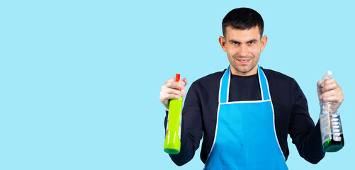 Banner-long format. Handsome man in rubber gloves and with spray guns in his hands posing and...