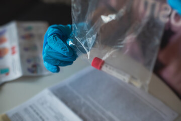 Process of coronavirus testing examination at home, COVID-19 swab collection kit, test tube for taking OP NP patient specimen sample, testing carried out, patient receiving a corona test