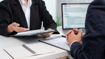 young businesswoman explaining about her profile and holding resume during corporate meeting or job interview with applicant to business human resources managers at office