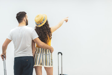 Back view of young couple pointing at wall.