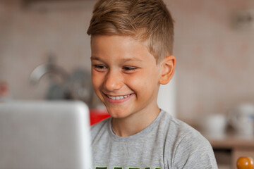 Happy elementary student having an online class over a computer at home.