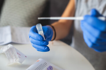 Process of coronavirus testing examination at home, COVID-19 swab collection kit, test tube for taking OP NP patient specimen sample, testing carried out, patient receiving a corona test
