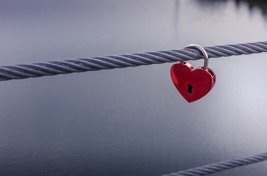 Red heart padlock with unfocused water background