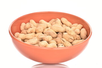Unpeeled organic peanuts, close-up, on a white background.