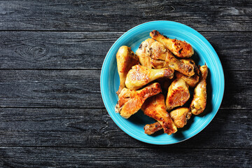 Crispy baked chicken drumsticks on a blue plate