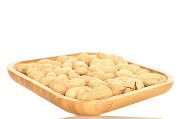 Unpeeled organic peanuts, close-up, on a white background.