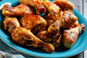Crispy baked chicken drumsticks on a blue plate