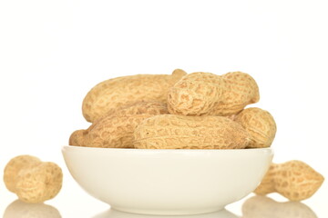 Unpeeled organic peanuts, close-up, on a white background.