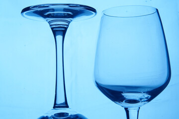 Perspective of two drinking glasses on blue background