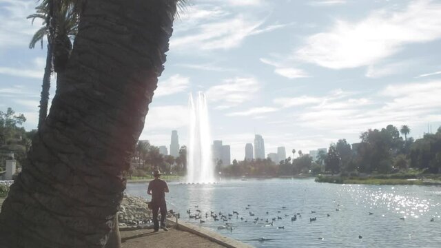 Single Man Goes Fishing Standing Up at Echo Park Lake, with Downtown LA City in Background