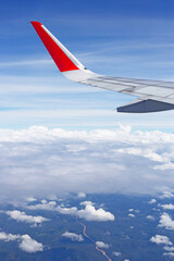 View of land, sky, cloud and wing of airplane from window