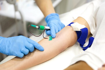 taking blood from a vein close-up. blood test in the hospital. the doctor's hands draw blood from a vein. blood sampling for plasma extraction