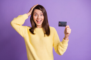 Naklejka premium Photo portrait of woman holding plastic card touching head hair with open mouth isolated on vivid purple colored background